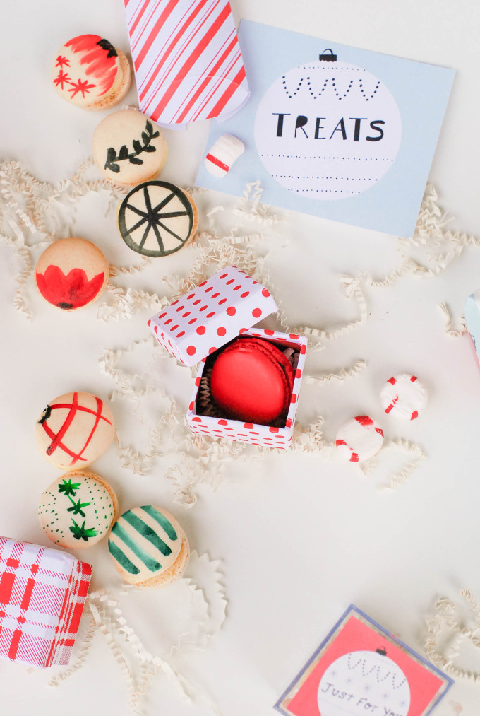 holiday printables on flatlay with decorated macaron cookies and ornaments