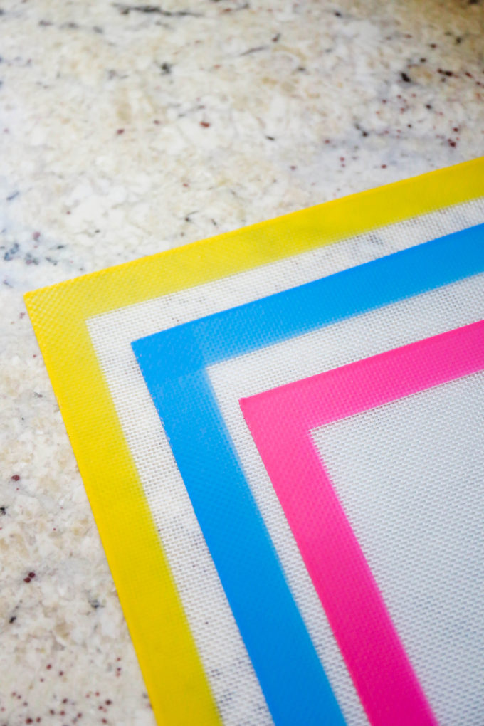 yellow, blue, and pink silicone baking mats on quartz countertop