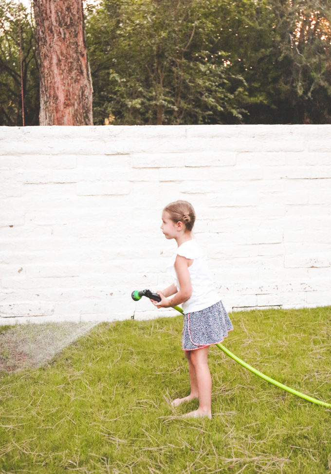 little girl holding hose 