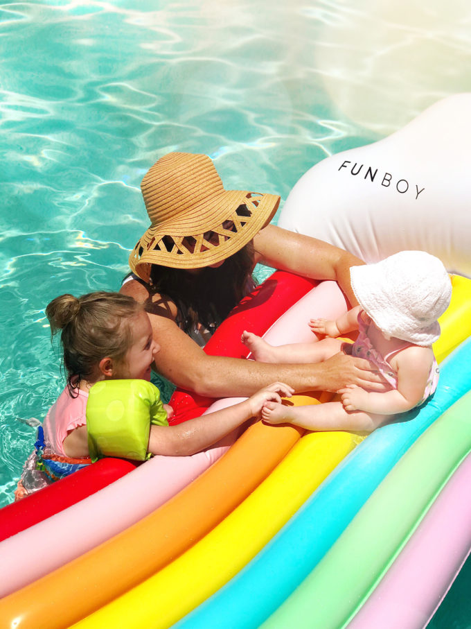 mom and daughters with rainbow pool float 