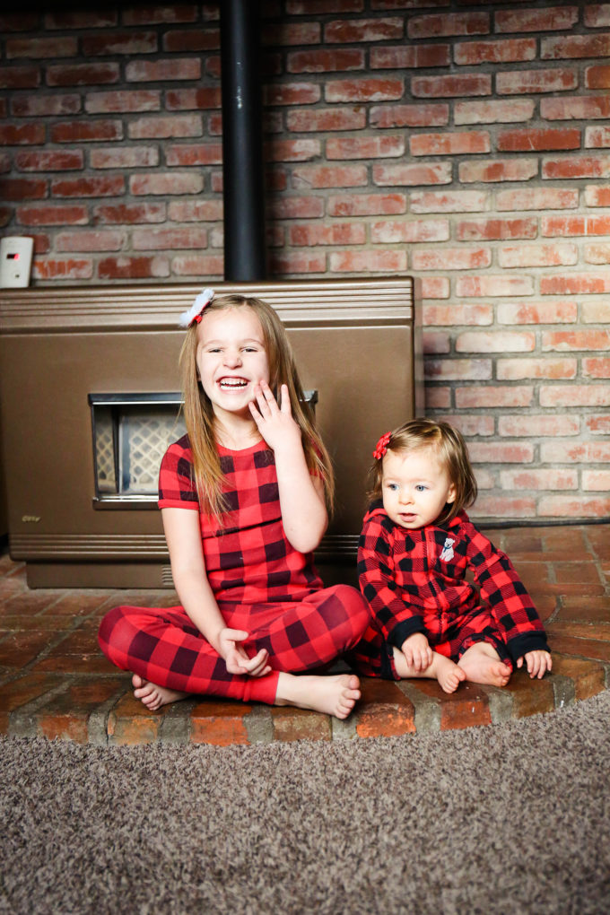 sisters in plaid pajamas in front of stove