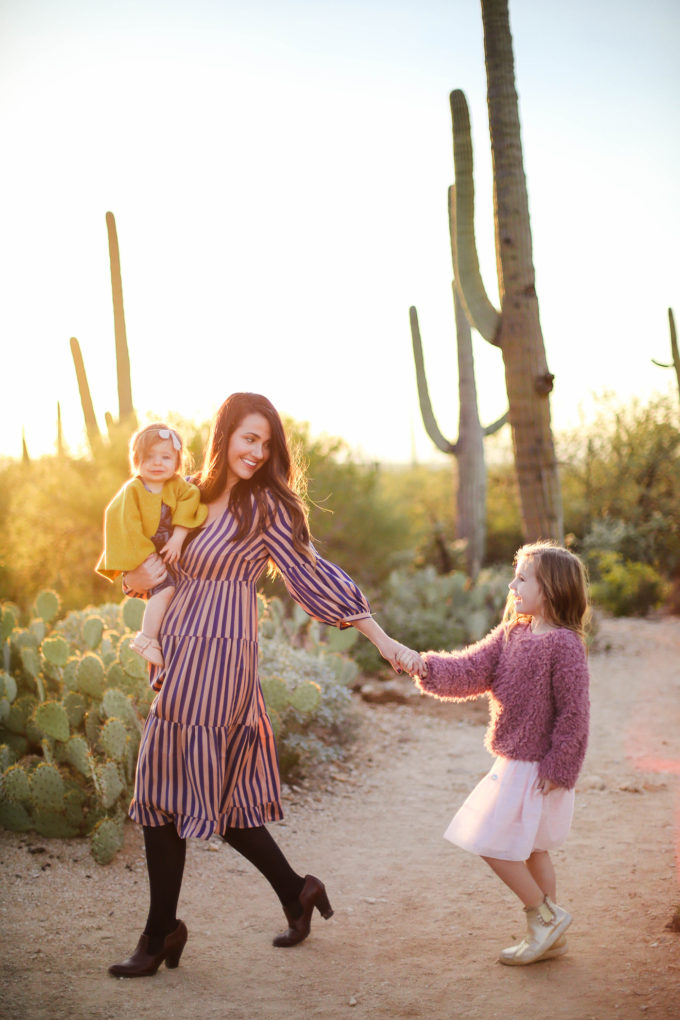 mom and daughters walk in desert