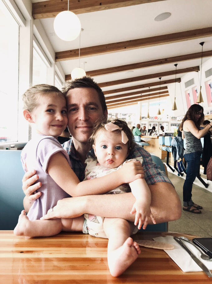 dad posing in diner with daughters 