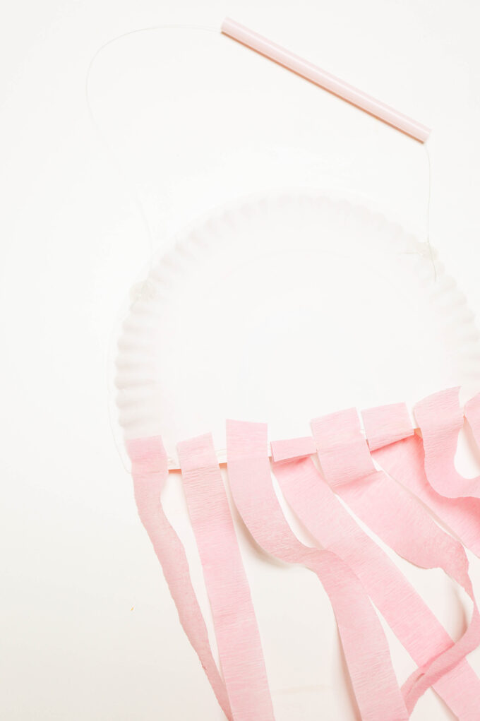 attaching tissue streamers to back of paper plate 