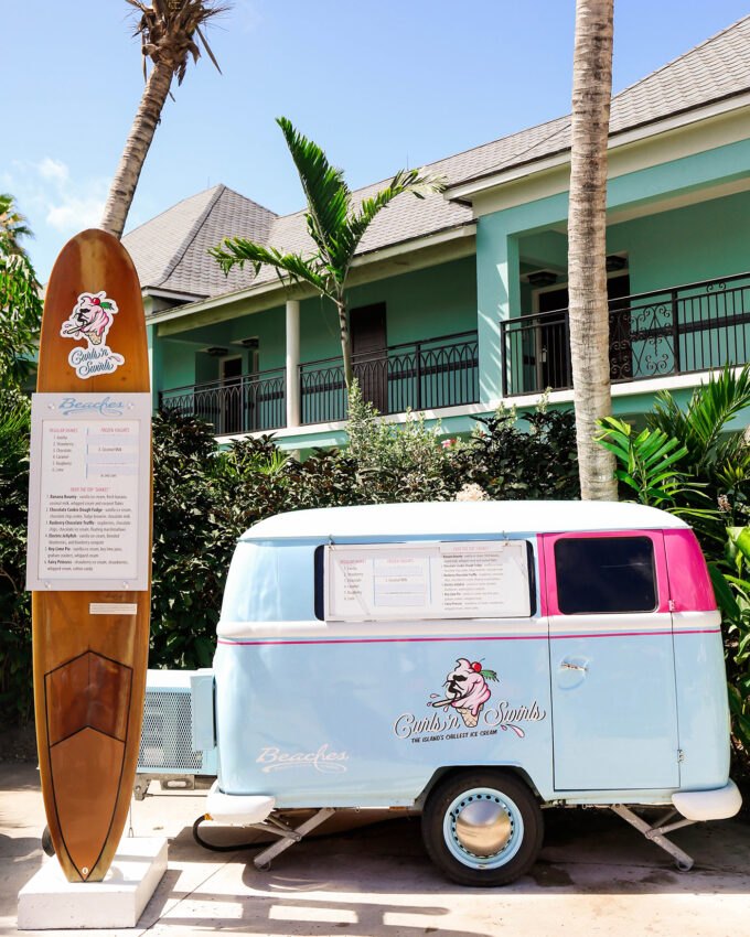 ice cream truck next to tall surf board