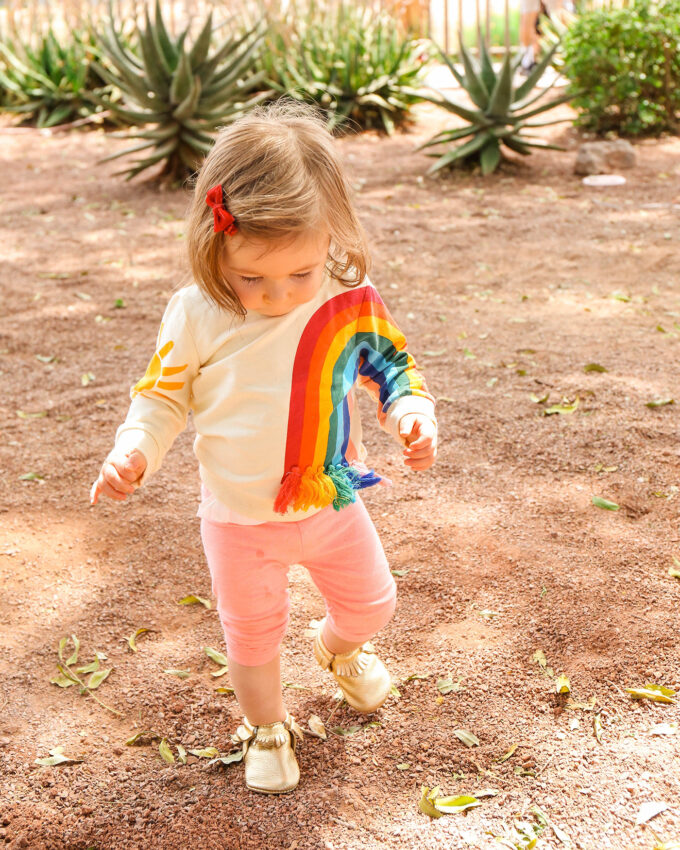 little toddler girl in rainbow sweater