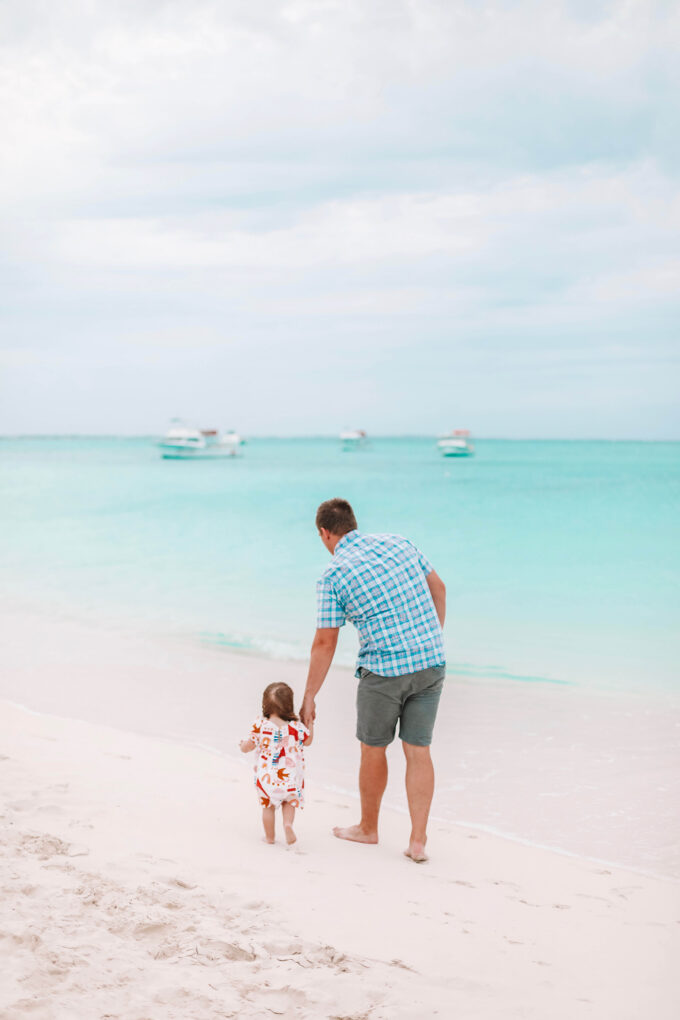 daddy and daughter walking on beach