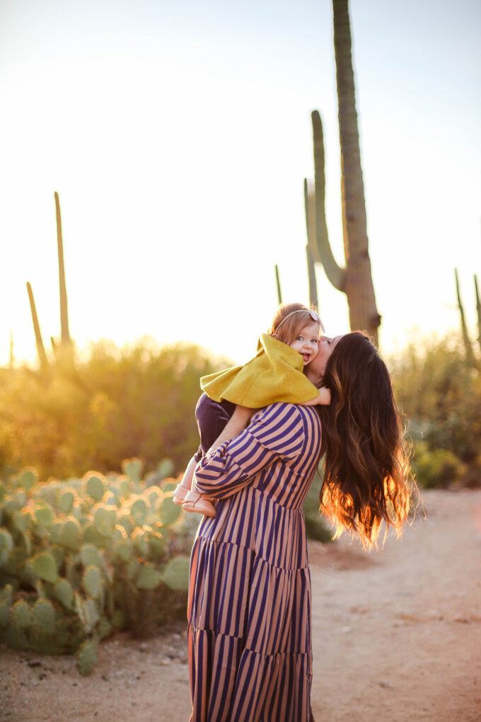 mom holding baby and kissing her cheek 