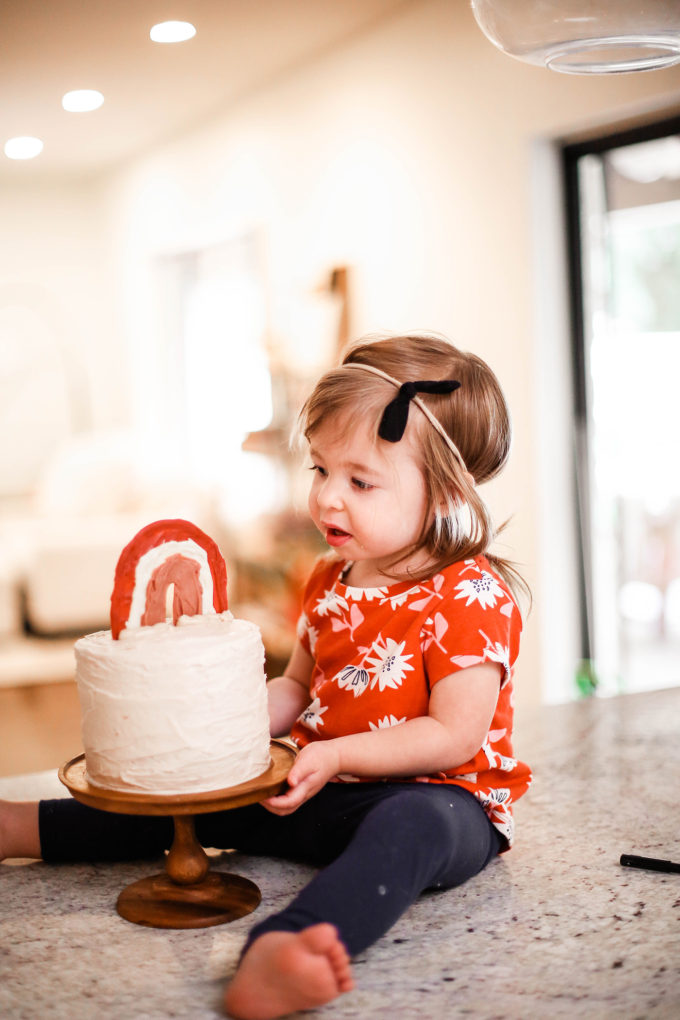 little girl staring at birthday cake 