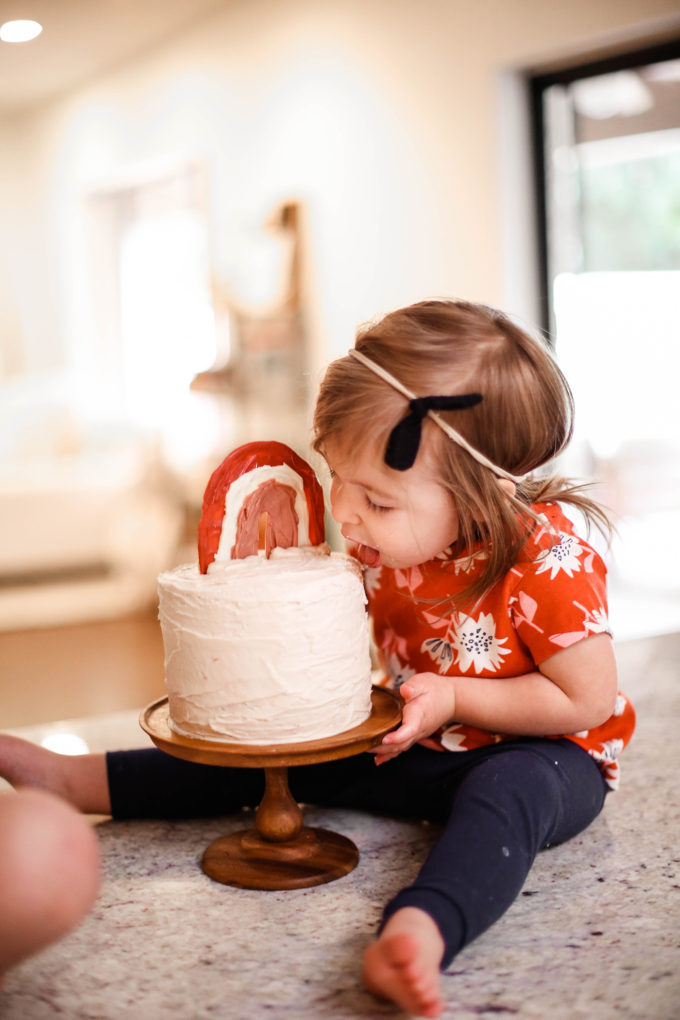 little girl taking a bite out of birthday cake 