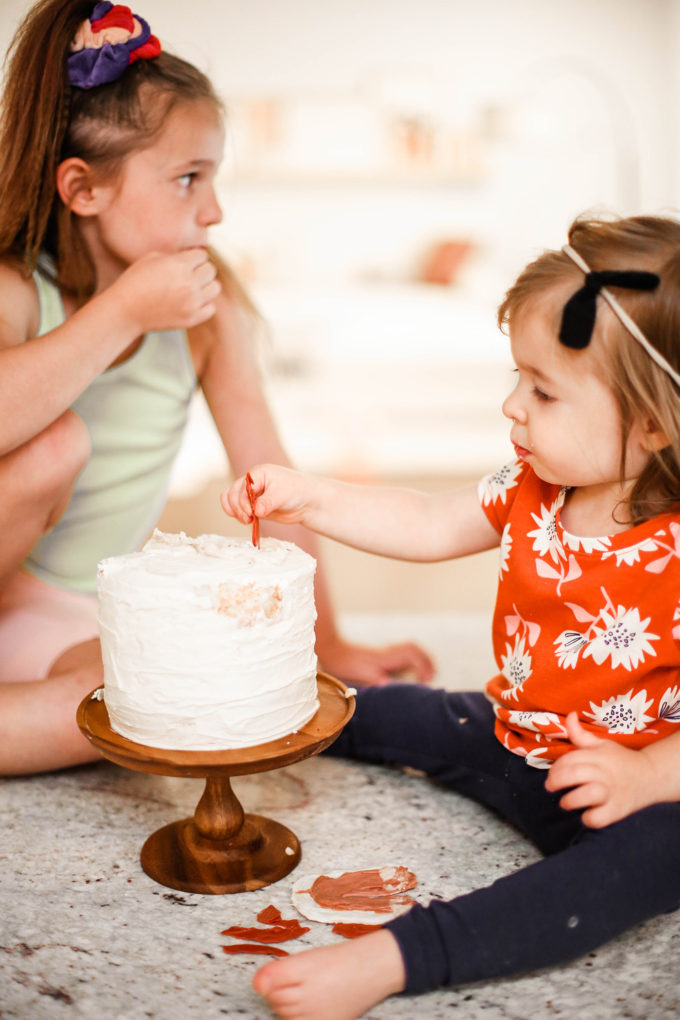 little girls playing with birthday cake 