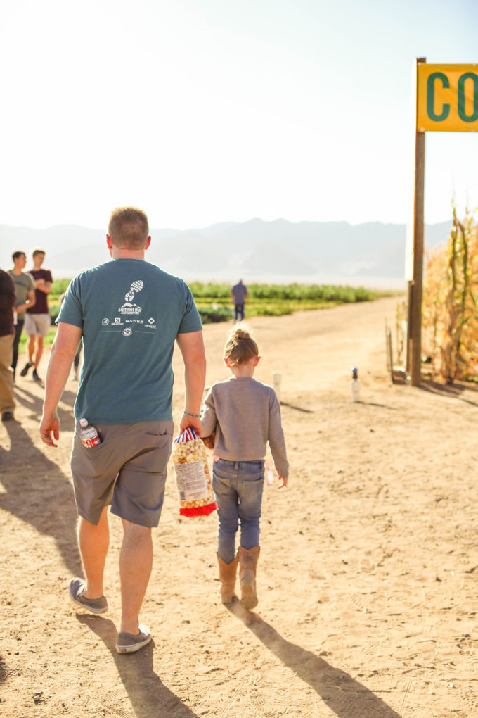 dad and daughter walking to corn field 