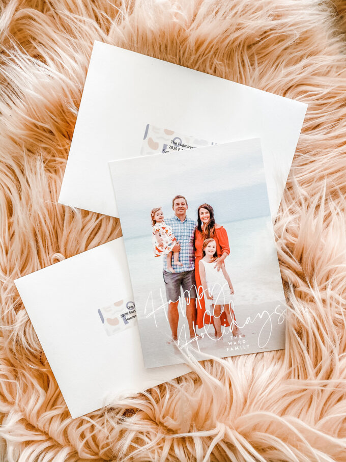 holiday cards and envelopes styled on pink fur blanket