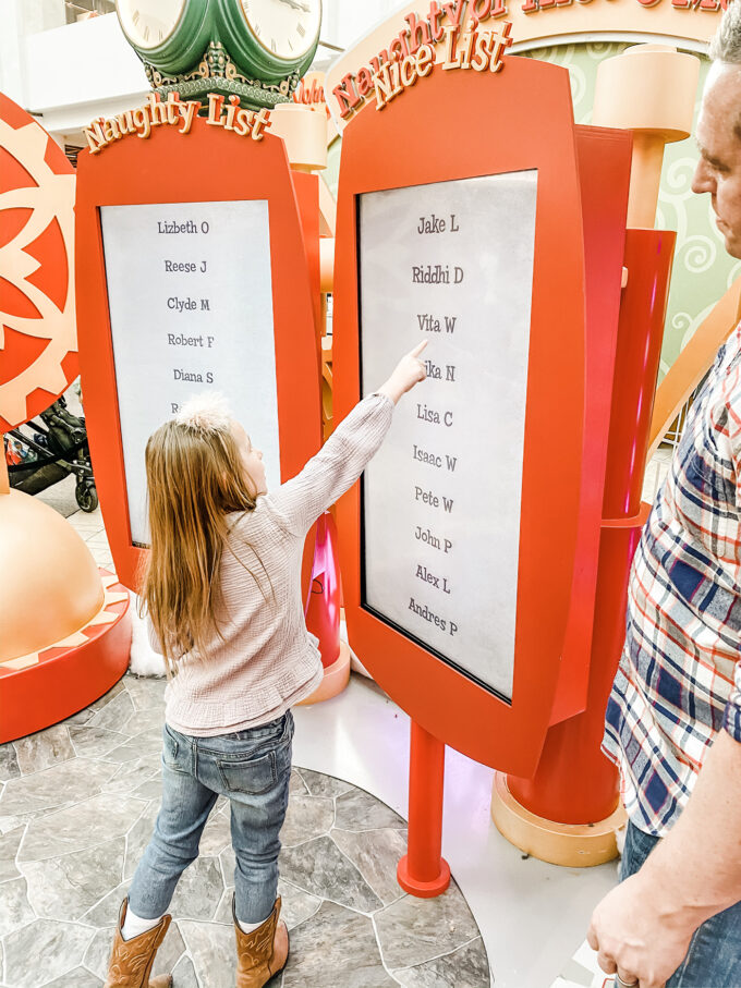 little girl pointing to her name being on Santa's "NICE" list