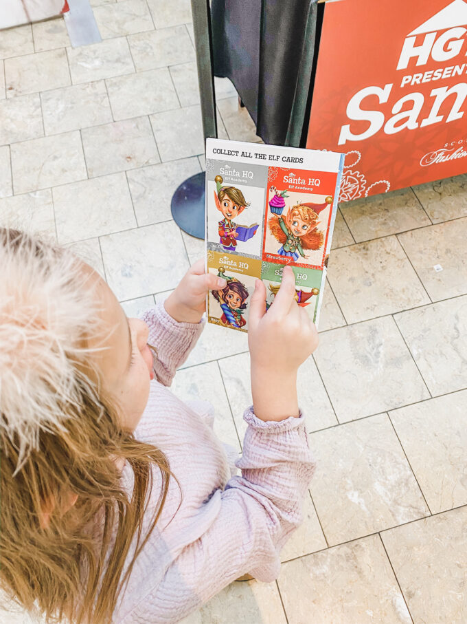 little girl holding elf activity cards