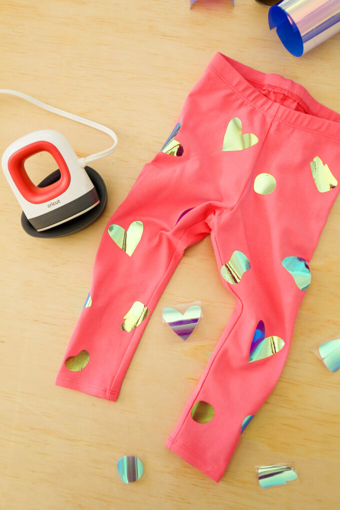 pink valentine's day leggings in flat lay setup with holographic shapes ironed on