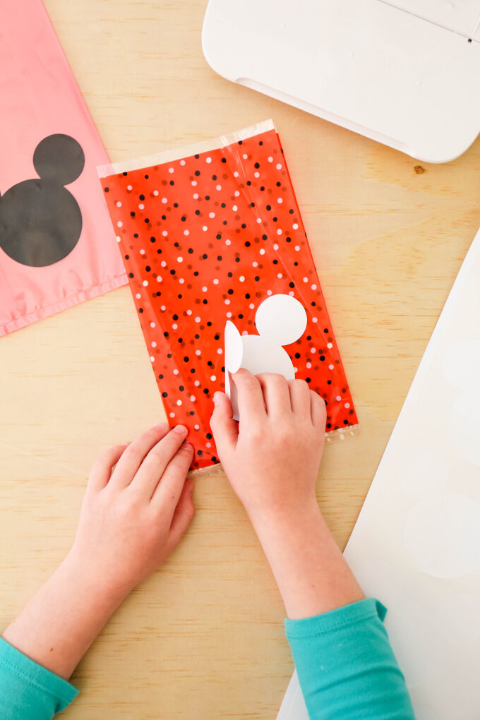 hands placing mickey sticker on favor bag