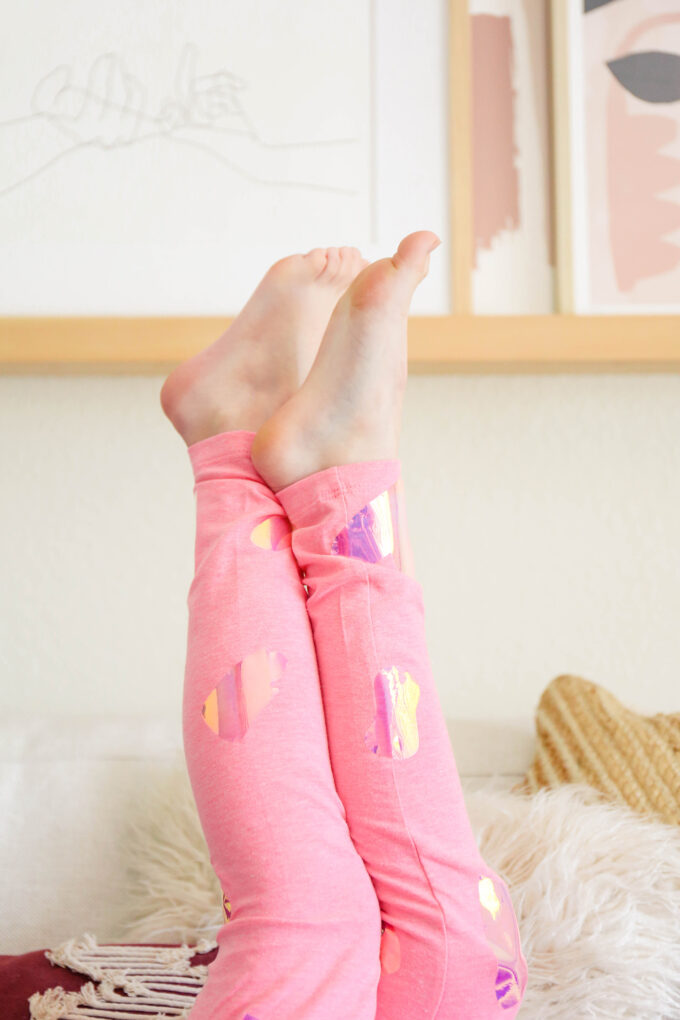 little girl's legs in the air with pink valentine's day leggings