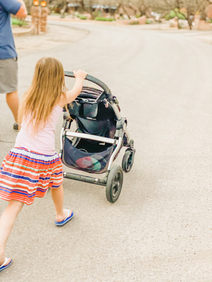 little girl pushing stroller 