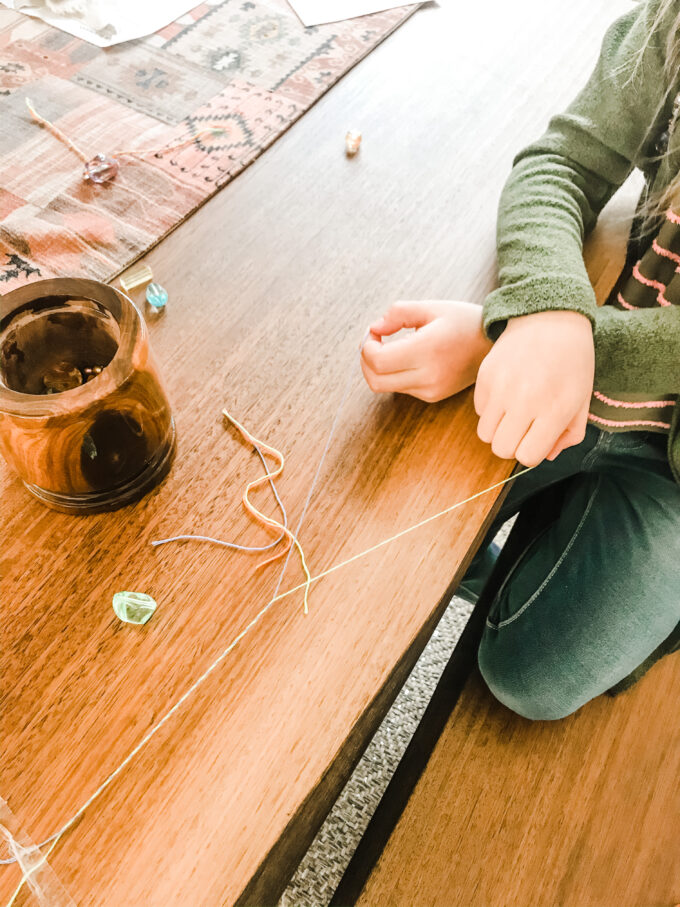 hands making friendship bracelets 