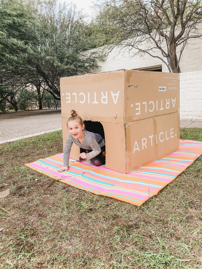 little girl in box fort 
