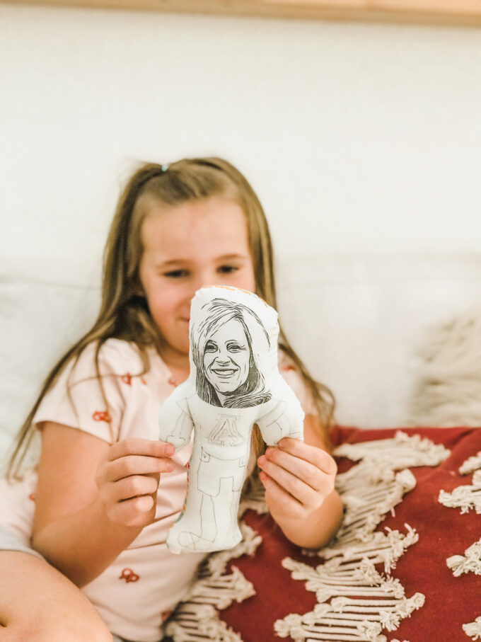 little girl holding homemade doll 