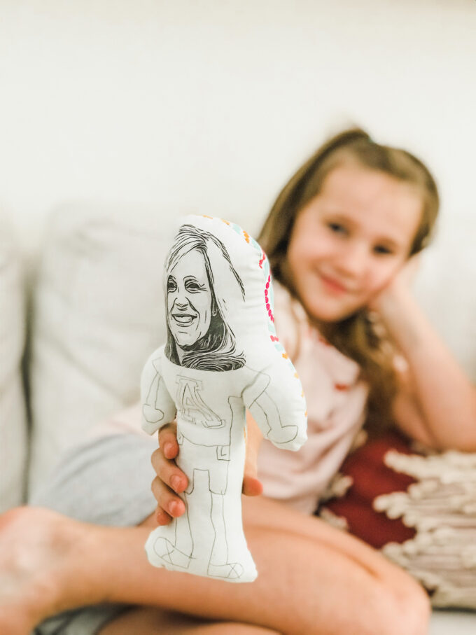 little girl holding homemade doll 