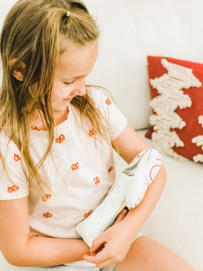 little girl holding homemade doll 